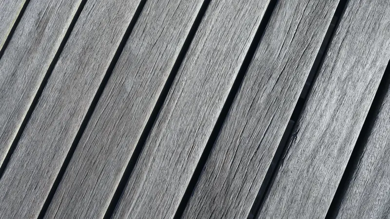 Lames de terrasse grises posées en diagonale, vues de près, avec un joint régulier entre chaque lame